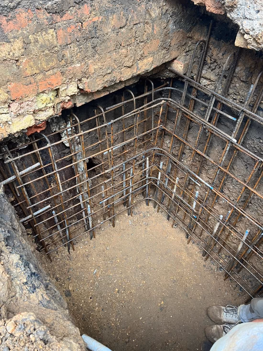 Deep excavation exposing existing foundations for underpinning and basement works in London