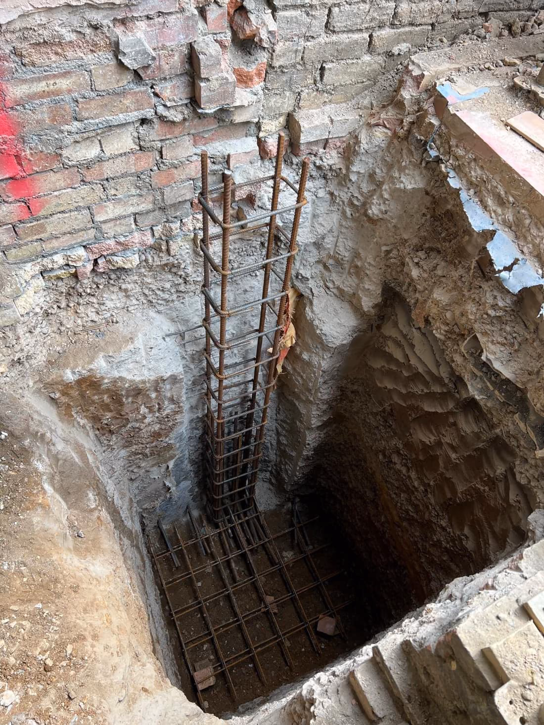 Deep excavation with reinforced concrete retaining walls formed beside existing foundations, London