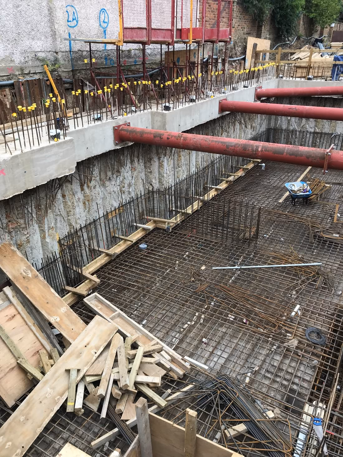 Steel reinforcement and formwork across a new basement floor ahead of a concrete pour, London
