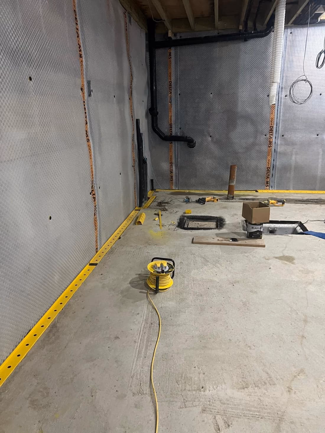 Finished basement structure with smooth concrete walls and perimeter drainage, London
