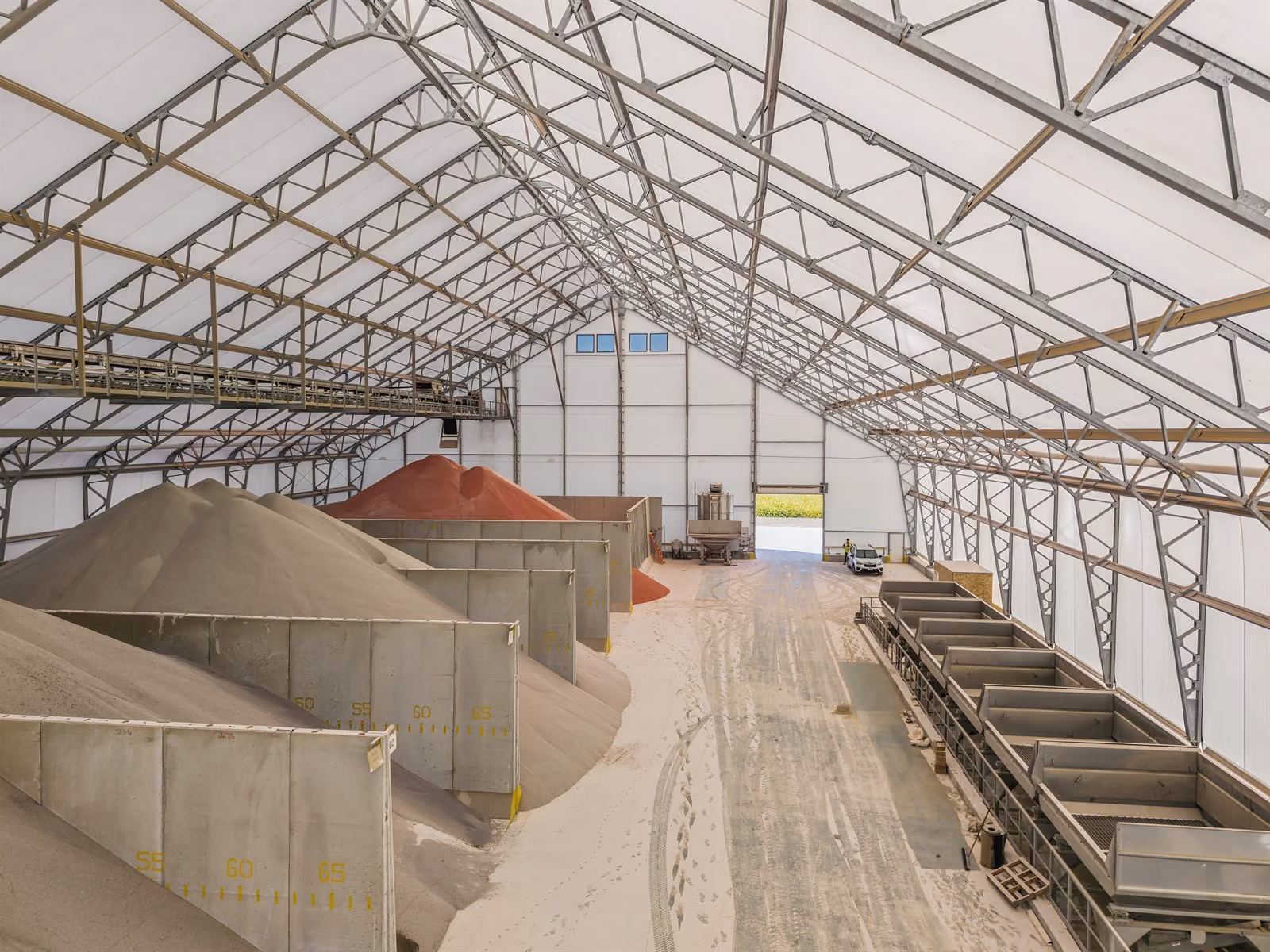 Interior of a Calhoun fabric structure showing the free-span steel frame above concrete storage bays