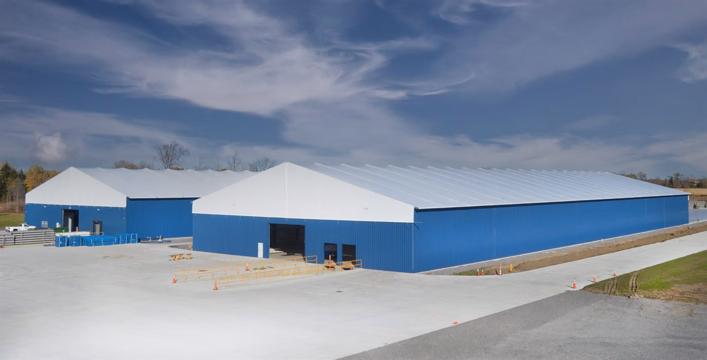 Blue-clad Calhoun fabric structures on steel legs at a commercial site