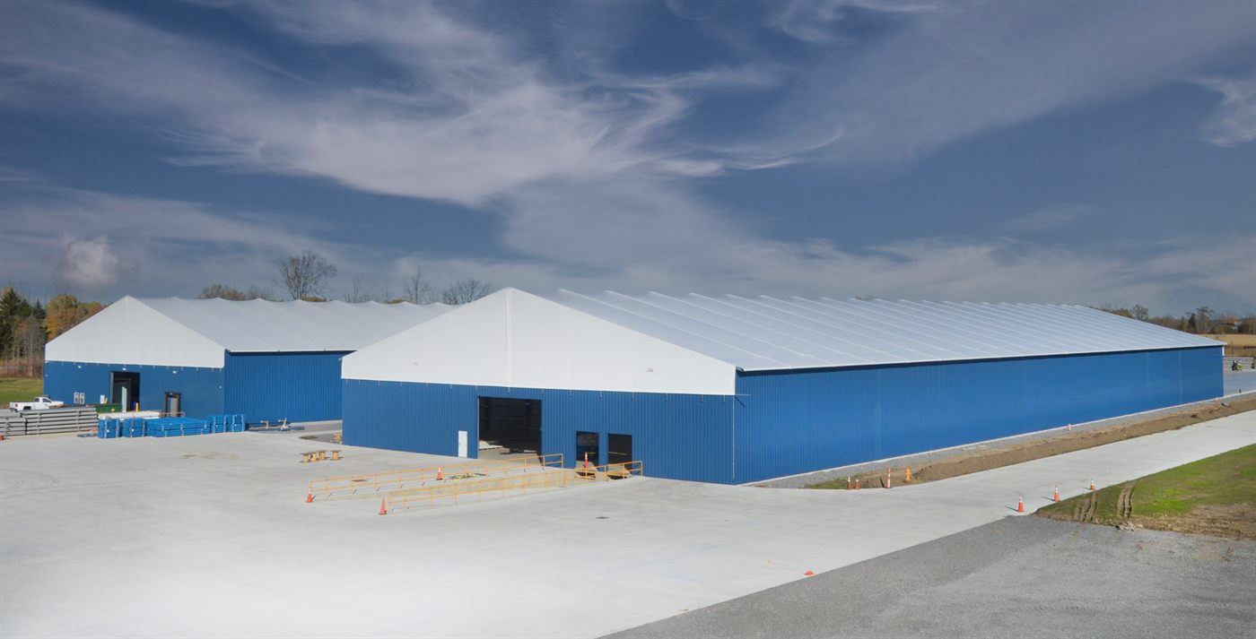 Blue-clad Calhoun fabric structures on steel legs at a commercial site