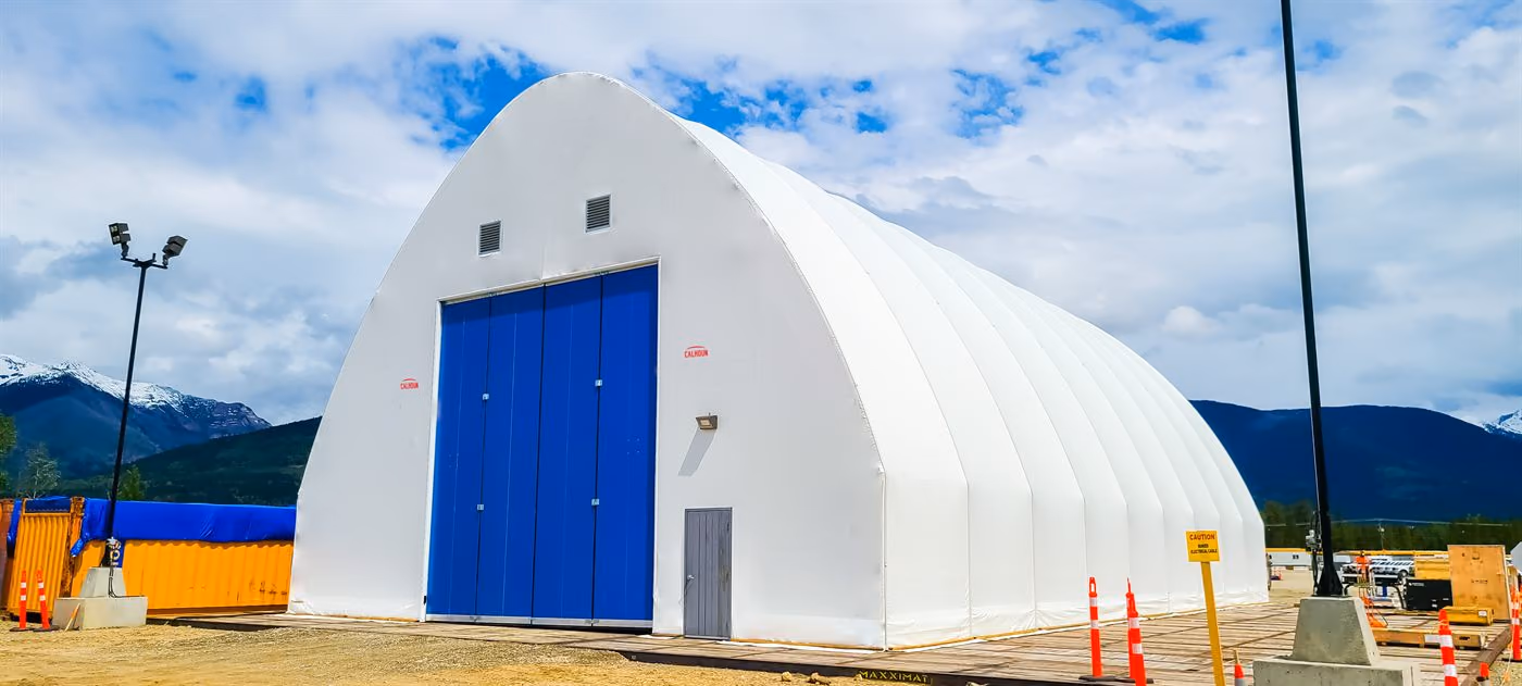 White Calhoun fabric building on galvanised steel legs with a roller door