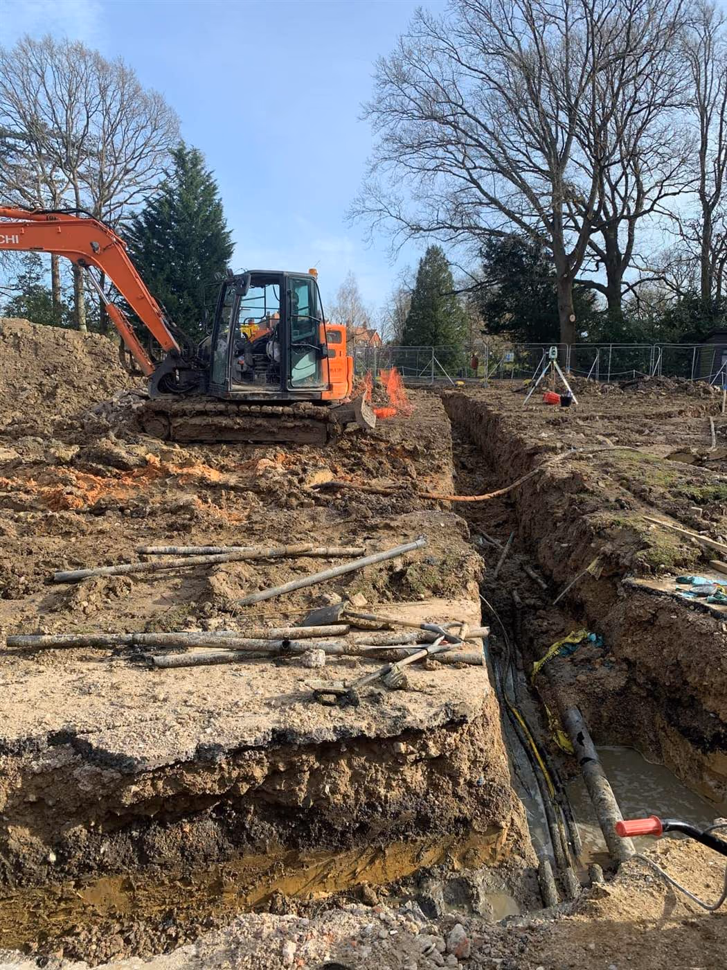 Excavator digging a foundation trench during groundworks at a London site