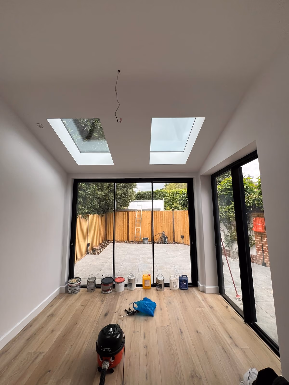 New open-plan room inside the extension with two roof lights and full-width sliding doors opening to the garden