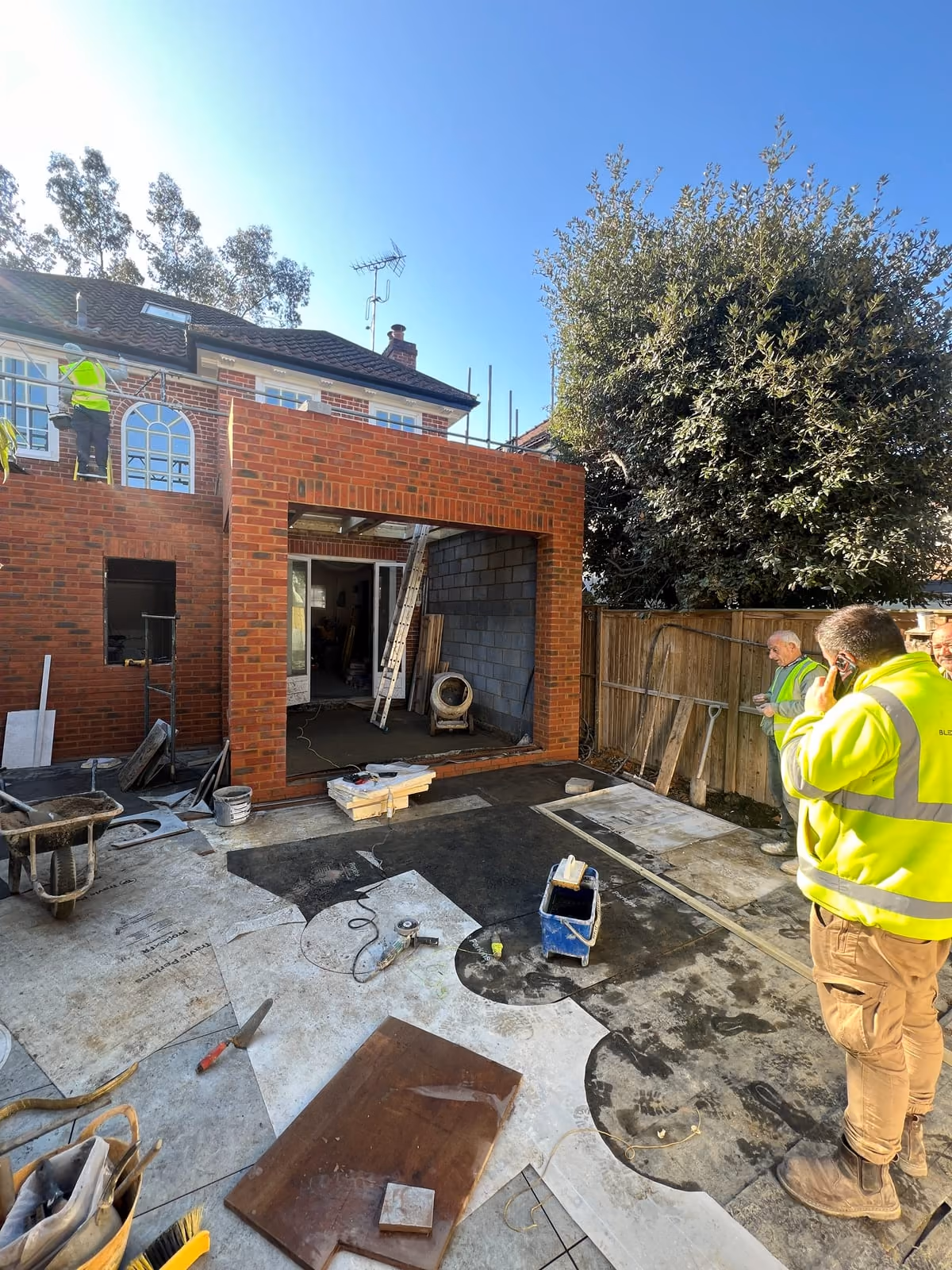The rear extension under construction, brickwork and opening formed for the glazed doors, with the site team working
