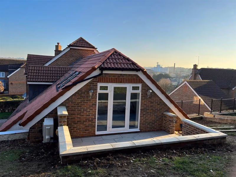 Completed rear extension at Epsom KT18 with a new tiled roof, brick walls and patio doors after structural remediation