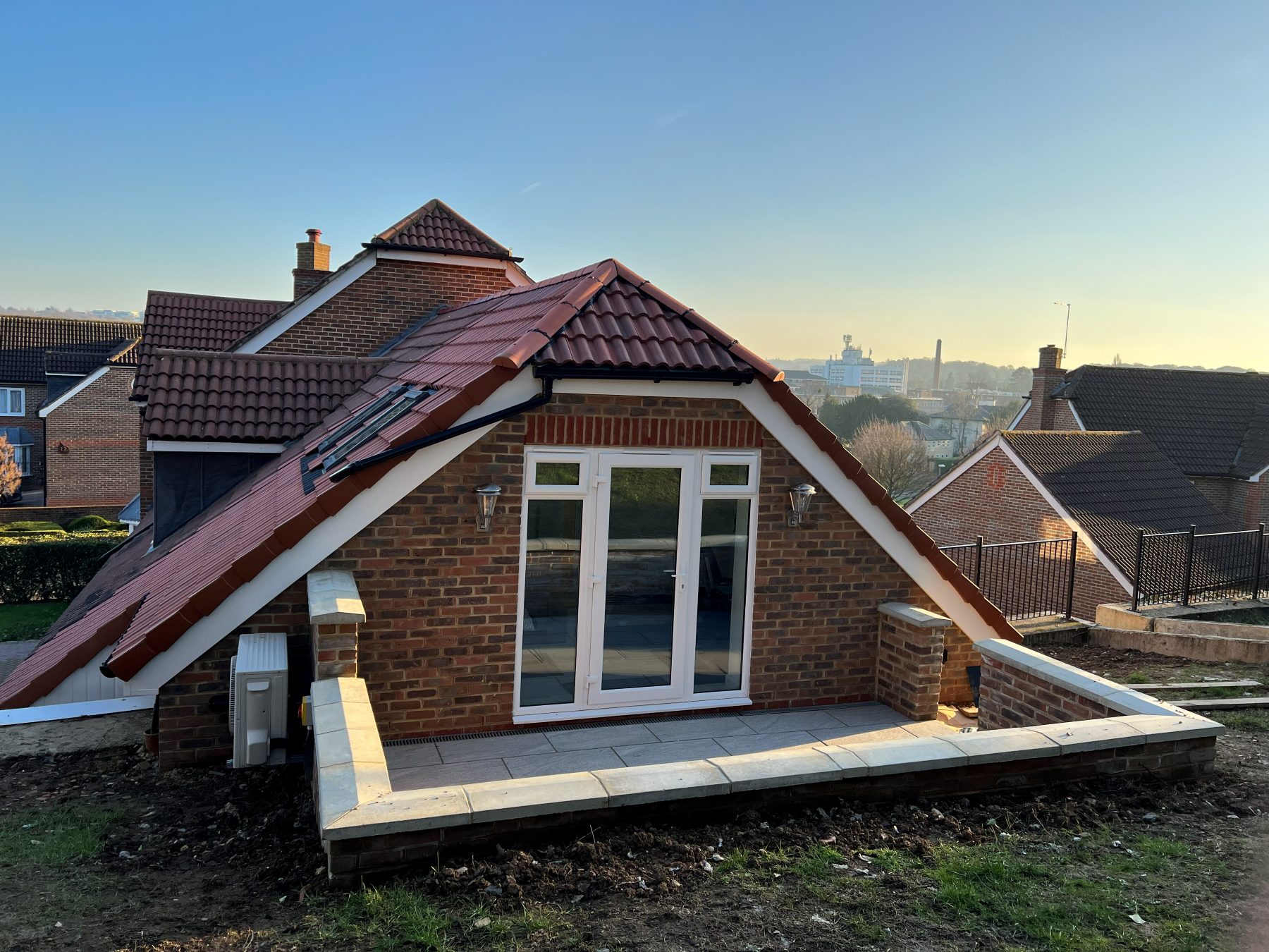 The completed second-floor extension in Epsom, Surrey, brick and tiled roof above the stabilised structure