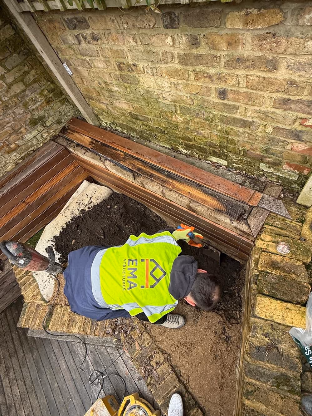 Exposed brick foundation footing revealed in a trial pit during a London structural investigation