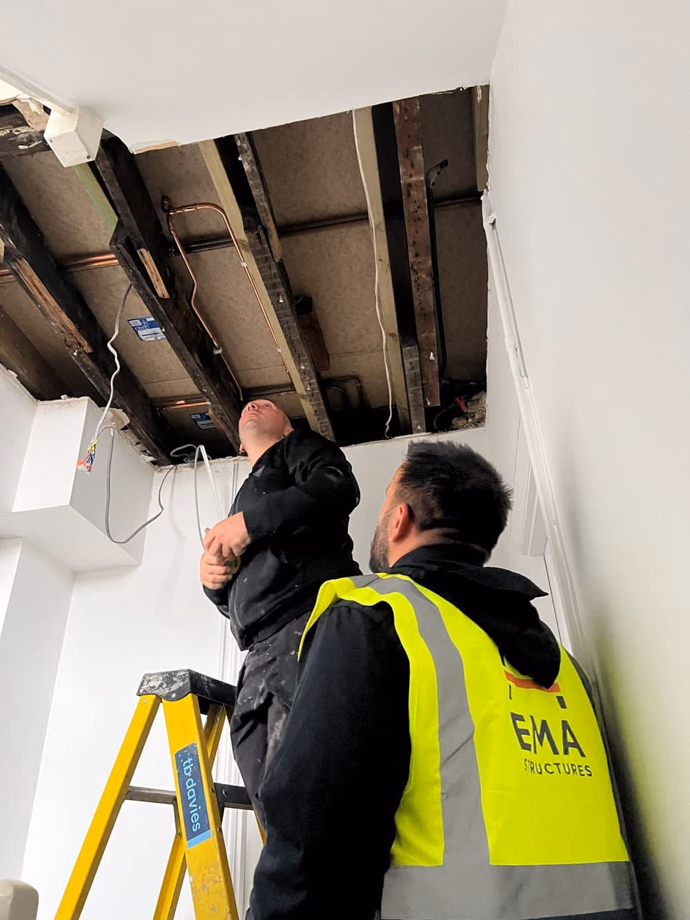 EMA Structures engineer inspecting exposed floor joists after opening up a ceiling in a London property